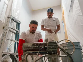 PaintMor Painters north dallas professional office painters getting ready to paint a room with a sprayer.