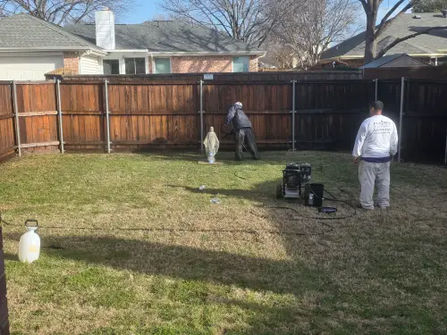paintmor workers power washing wooden fence to prep for fence staining