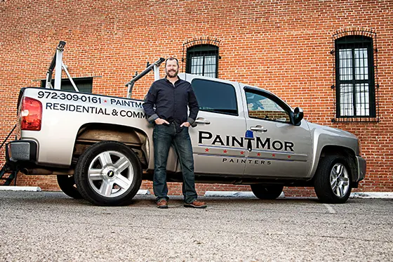 Image of Tim Cann standing infront of a PaintMor Painters branded pickup truck.