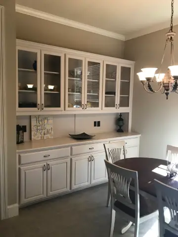 a dining room with white cabinets and a table