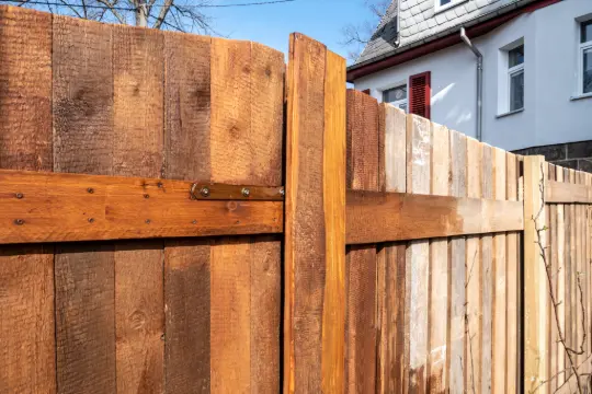 PaintMor Painters professional fence staining and painting in Richardson showing a wooden fence that is being stained.