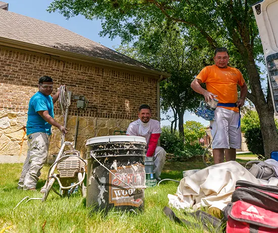 PinterMor Painters taking a break from painting fences looking over their materials.