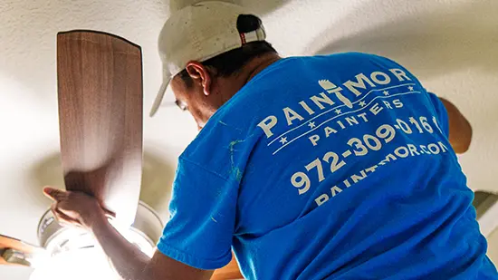 PaintMor Professional interior painting services, painter painting around ceiling fan.