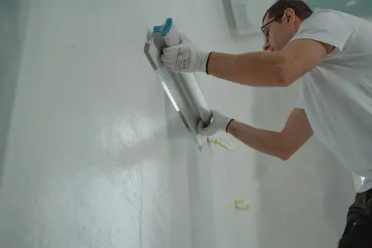 PaintMor Painters professional interior & exterior painters in Frisco showing a painter doing some popcorn removal.